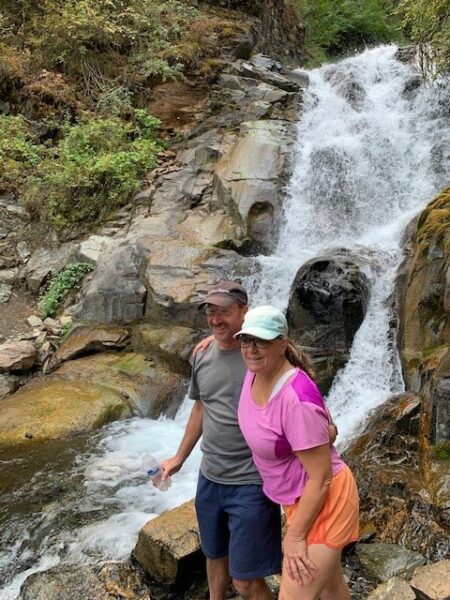 couple standing in front of waterfall