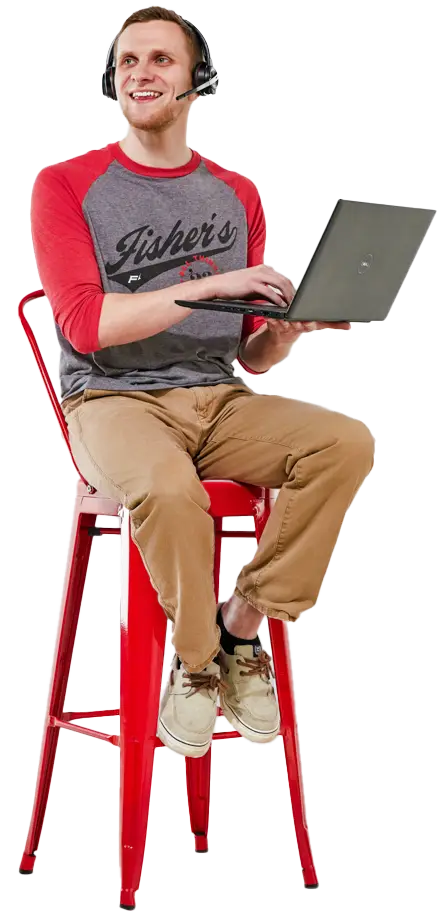 Man in headphones using laptop on red stool